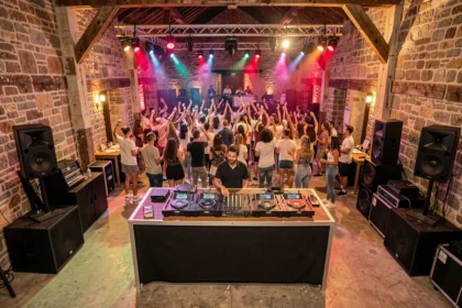 Vue panoramique d'un événement DJ en Bourgogne-Franche-Comté avec une foule animée dans une salle au décor mêlant pierre ancienne et équipements modernes