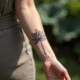 Poignet d'une femme avec tatouage lotus en fine ligne